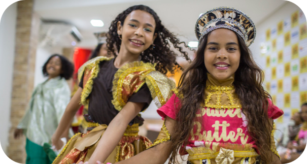 Duas crianças com fantasias amarelas brilhantes sorrindo.